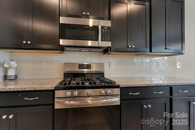 2309 Abundance Ln, Waxhaw, NC 28173 - kitchen featuring appliances with stainless steel finishes, backsplash, and light stone countertops