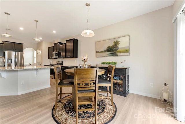 2309 Abundance Ln, Waxhaw, NC 28173 - dining area featuring arched walkways, light wood-style flooring, and recessed lighting