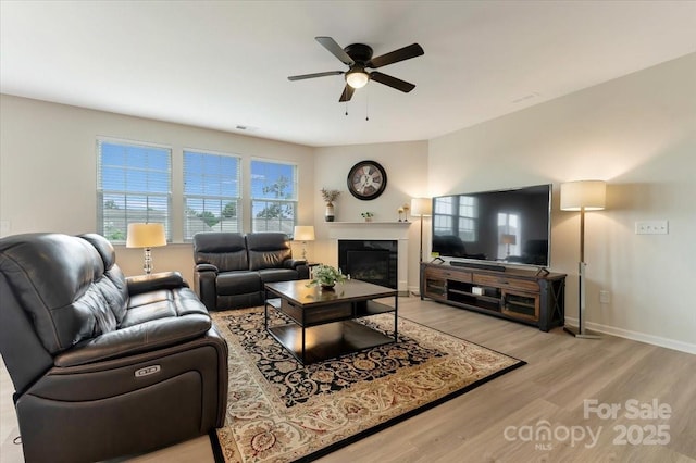 2309 Abundance Ln, Waxhaw, NC 28173 - living area featuring light wood finished floors, ceiling fan, and a glass covered fireplace