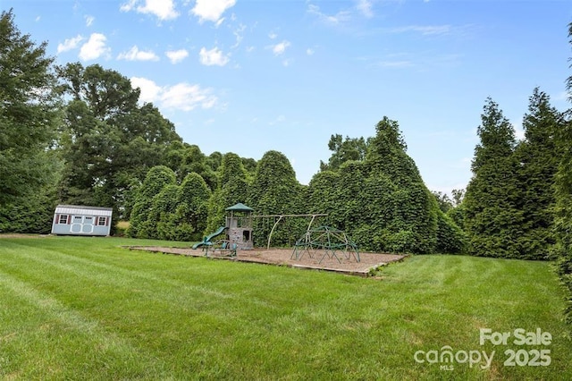 141 Maplewood Ct, Hudson, NC 28638 - view of grassy yard with a playground, a storage unit, and a wooded view