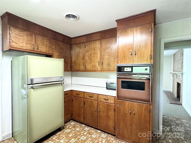 1586 Echo Dr, Lenoir, NC 28645 - kitchen featuring wall oven, light countertops, brown cabinetry, and a fireplace