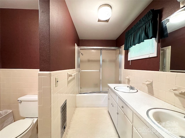 1586 Echo Dr, Lenoir, NC 28645 - full bathroom featuring tile walls, double vanity, wainscoting, and bath / shower combo with glass door
