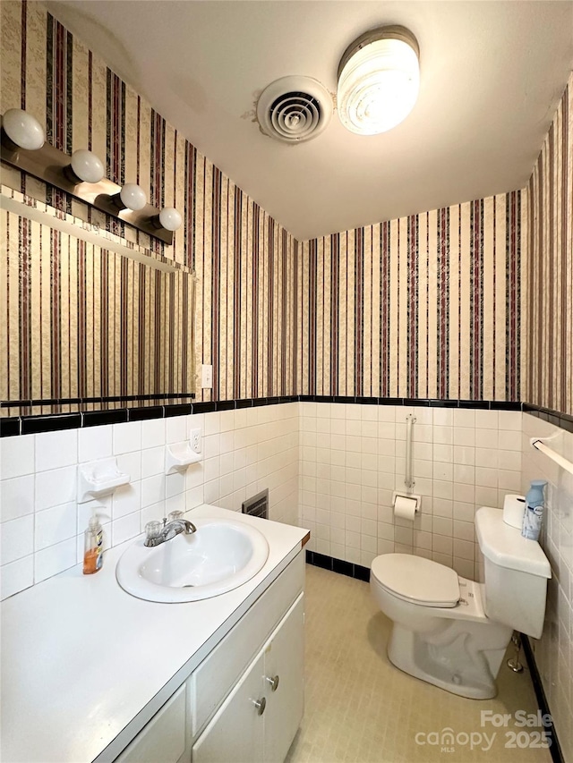1586 Echo Dr, Lenoir, NC 28645 - bathroom featuring wallpapered walls, tile walls, wainscoting, vanity, and tile patterned flooring
