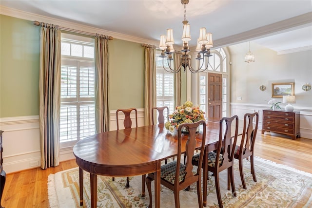 5604 Yorke St NW, Concord, NC 28027 - dining area with a chandelier, wainscoting, light wood-style flooring, ornamental molding, and a decorative wall