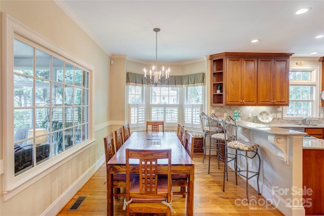 5604 Yorke St NW, Concord, NC 28027 - dining area featuring a chandelier, light wood finished floors, crown molding, and recessed lighting