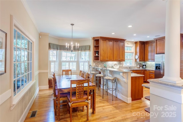 5604 Yorke St NW, Concord, NC 28027 - dining space with ornate columns, a chandelier, light wood-style flooring, crown molding, and recessed lighting