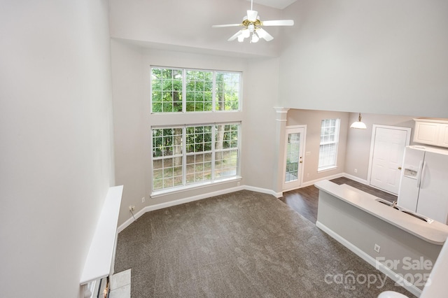 6721 Charter Hills Rd, Charlotte, NC 28277 - unfurnished living room featuring a high ceiling, ceiling fan, dark colored carpet, and healthy amount of natural light