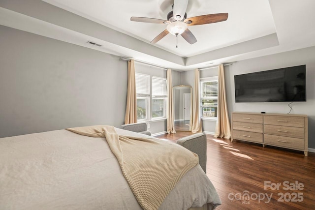 9846 Bailey Rd, Cornelius, NC 28031 - bedroom featuring dark wood-type flooring, a raised ceiling, and ceiling fan