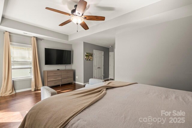 9846 Bailey Rd, Cornelius, NC 28031 - bedroom featuring wood finished floors, a tray ceiling, and ceiling fan