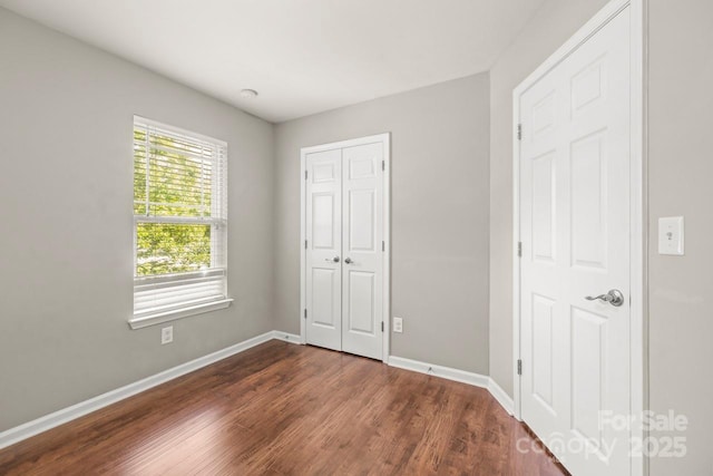 9846 Bailey Rd, Cornelius, NC 28031 - unfurnished bedroom with dark wood-type flooring and a closet