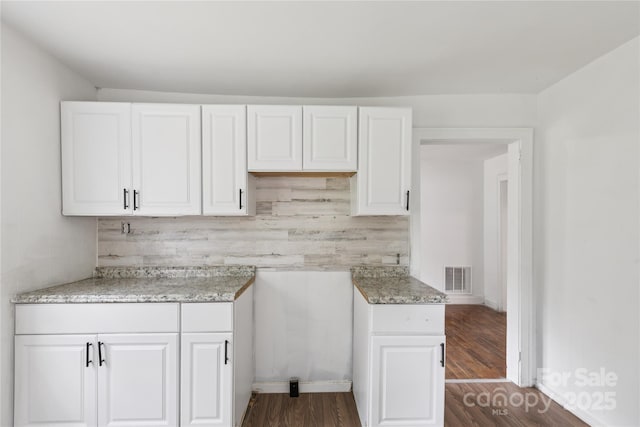 1208 Arch St E Unit 10, Lancaster, SC 29720 - kitchen featuring white cabinetry, decorative backsplash, dark wood-style flooring, and light stone counters