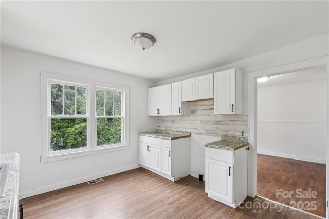 1208 Arch St E Unit 10, Lancaster, SC 29720 - kitchen featuring light wood-style flooring, white cabinets, tasteful backsplash, and light stone counters