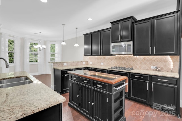 12515 Hashanli Pl, Matthews, NC 28105 - kitchen with dark cabinetry, stainless steel microwave, a center island, gas cooktop, and a chandelier