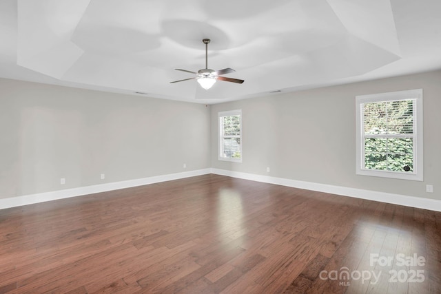 12515 Hashanli Pl, Matthews, NC 28105 - empty room featuring a tray ceiling, dark wood-style flooring, and a ceiling fan