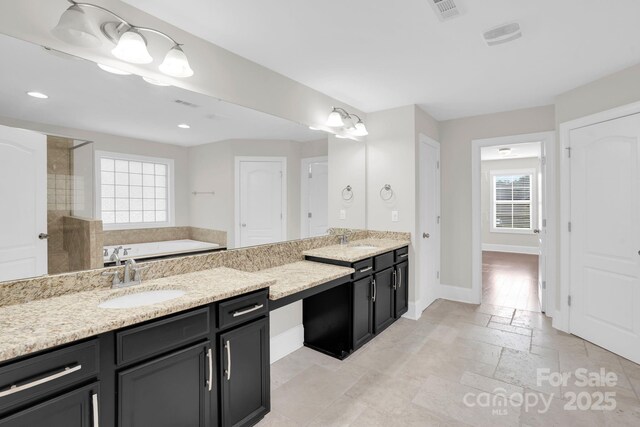 12515 Hashanli Pl, Matthews, NC 28105 - bathroom featuring double vanity, a garden tub, recessed lighting, tiled shower, and stone tile floors