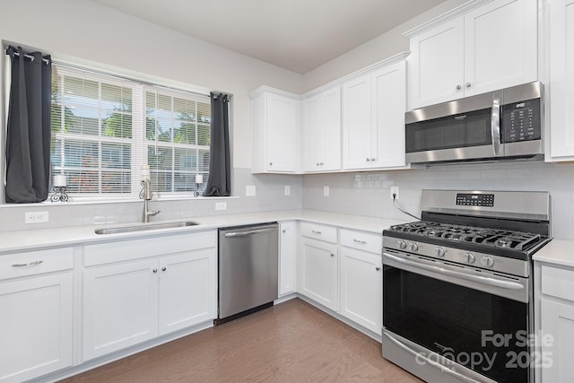 3013 Whipcord Dr, Waxhaw, NC 28173 - kitchen with appliances with stainless steel finishes, tasteful backsplash, light countertops, white cabinets, and wood finished floors