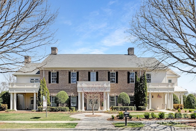 3013 Whipcord Dr, Waxhaw, NC 28173 - colonial-style house with a chimney, brick siding, a front lawn, and a balcony