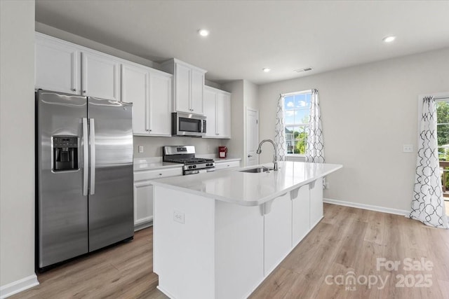 512 Whitehall Cir, Durham, NC 27713 - kitchen with appliances with stainless steel finishes, white cabinetry, plenty of natural light, light wood finished floors, and recessed lighting
