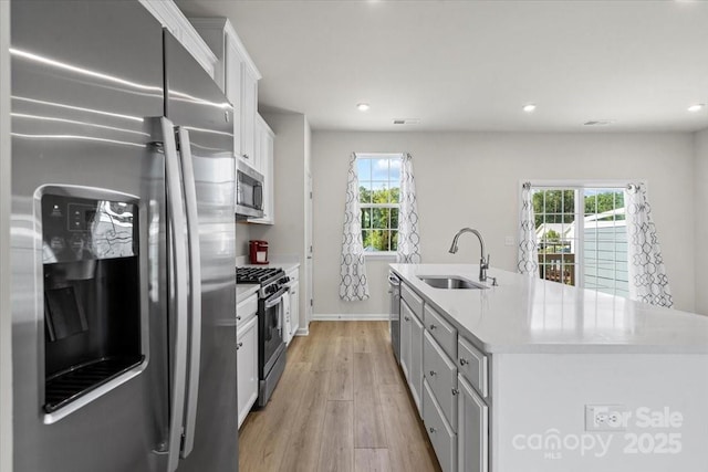 512 Whitehall Cir, Durham, NC 27713 - kitchen with stainless steel appliances, plenty of natural light, light wood-style flooring, white cabinetry, and recessed lighting