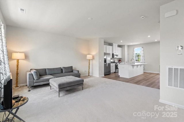 512 Whitehall Cir, Durham, NC 27713 - carpeted living room with recessed lighting and wood finished floors