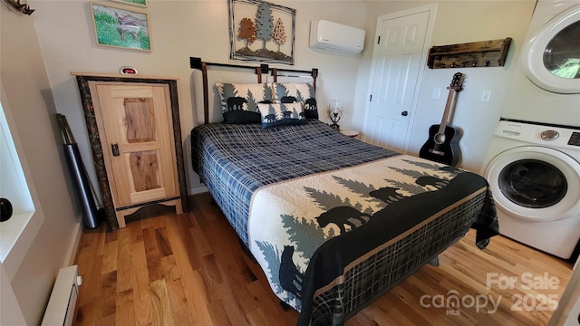 1594 High Valley Way, Lenoir, NC 28645 - bedroom featuring estacked washer and dryer, a wall unit AC, a baseboard heating unit, and wood finished floors