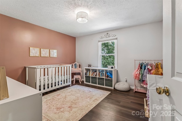 207 Jacksons Run, Morganton, NC 28655 - bedroom with wood finished floors, a textured ceiling, and a crib