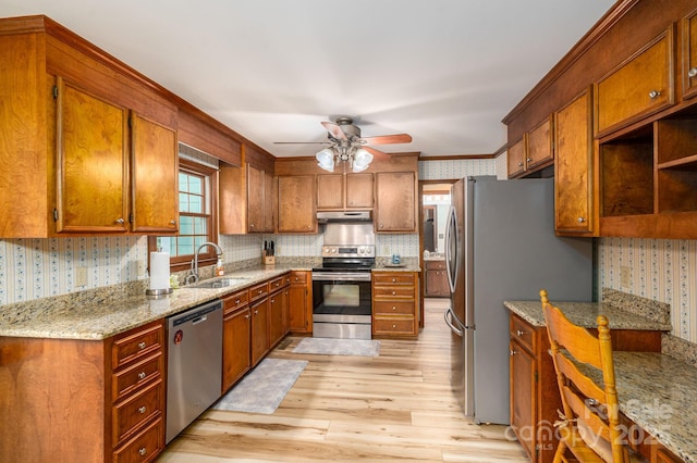 14409 Hackamore Dr, Matthews, NC 28105 - kitchen with wallpapered walls, stainless steel appliances, light wood-style floors, ceiling fan, and brown cabinetry