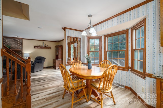 14409 Hackamore Dr, Matthews, NC 28105 - dining room featuring wallpapered walls, ornamental molding, light wood-style flooring, and a chandelier