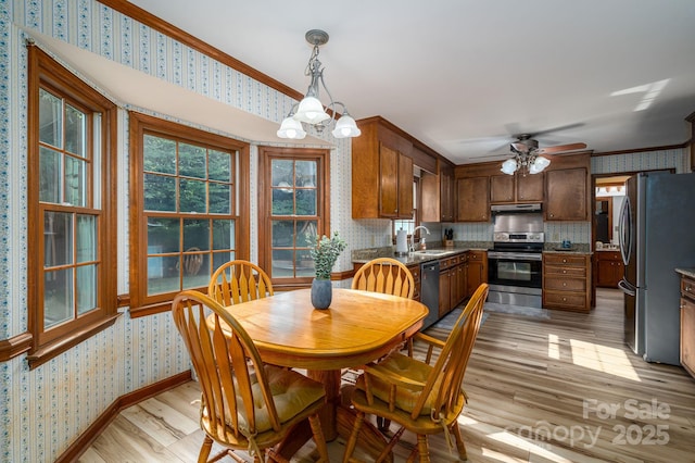 14409 Hackamore Dr, Matthews, NC 28105 - dining area with wallpapered walls, light wood finished floors, crown molding, a chandelier, and ceiling fan