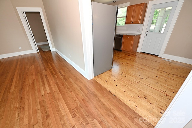 737 8th St SW, Hickory, NC 28602 - kitchen featuring light wood-style floors, freestanding refrigerator, brown cabinetry, and dishwasher