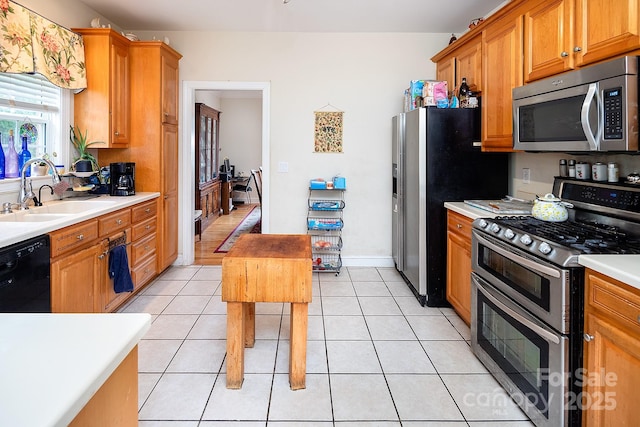 122 Hazeltine Ct, Salisbury, NC 28144 - kitchen featuring appliances with stainless steel finishes, light countertops, light tile patterned flooring, and brown cabinetry