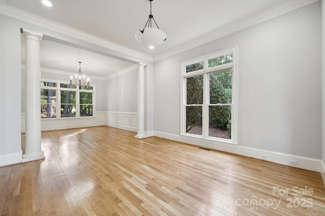 18802 Pentwater Ct, Cornelius, NC 28031 - spare room with ornate columns, healthy amount of natural light, light wood-style floors, ornamental molding, and wainscoting