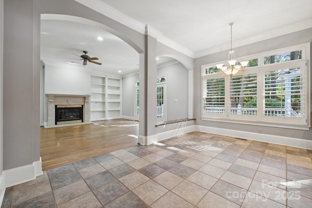 18802 Pentwater Ct, Cornelius, NC 28031 - unfurnished living room with a ceiling fan, built in shelves, arched walkways, a chandelier, and ornamental molding