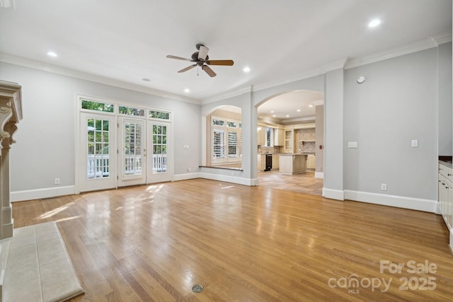 18802 Pentwater Ct, Cornelius, NC 28031 - unfurnished living room featuring a ceiling fan, arched walkways, ornamental molding, light wood finished floors, and recessed lighting
