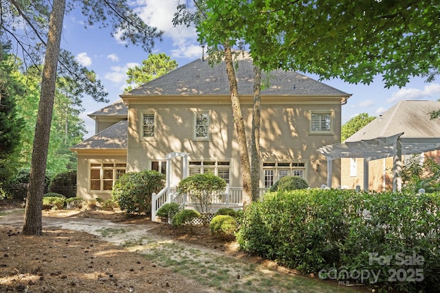 18802 Pentwater Ct, Cornelius, NC 28031 - back of property featuring stucco siding, a pergola, and a shingled roof