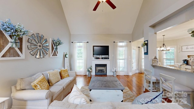 3005 Monterrey Ln, Monroe, NC 28110 - living room featuring a ceiling fan, high vaulted ceiling, a fireplace, wood finished floors, and a chandelier