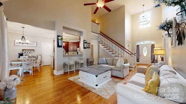 3005 Monterrey Ln, Monroe, NC 28110 - living area with a chandelier, stairs, ceiling fan, light wood finished floors, and a towering ceiling