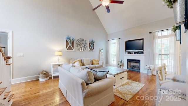 3005 Monterrey Ln, Monroe, NC 28110 - living area with high vaulted ceiling, stairway, ceiling fan, a fireplace, and light wood-style flooring