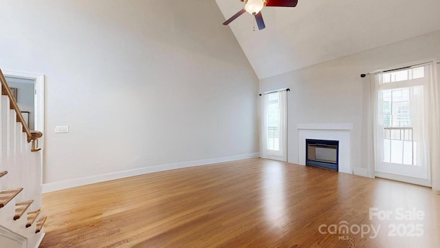 3005 Monterrey Ln, Monroe, NC 28110 - unfurnished living room featuring stairway, ceiling fan, plenty of natural light, high vaulted ceiling, and light wood finished floors