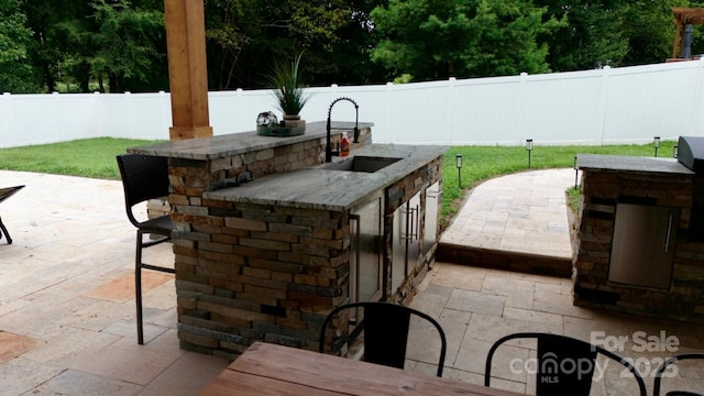 3005 Monterrey Ln, Monroe, NC 28110 - fenced backyard featuring an outdoor kitchen and a patio