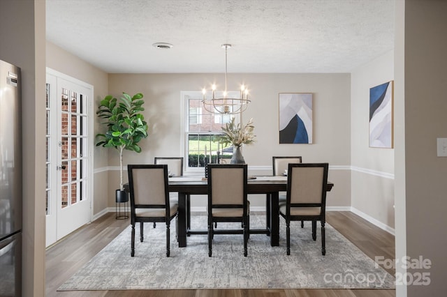 1409 Kensington Rd Unit B-8, Hendersonville, NC 28791 - dining space featuring a chandelier, wood finished floors, and a textured ceiling