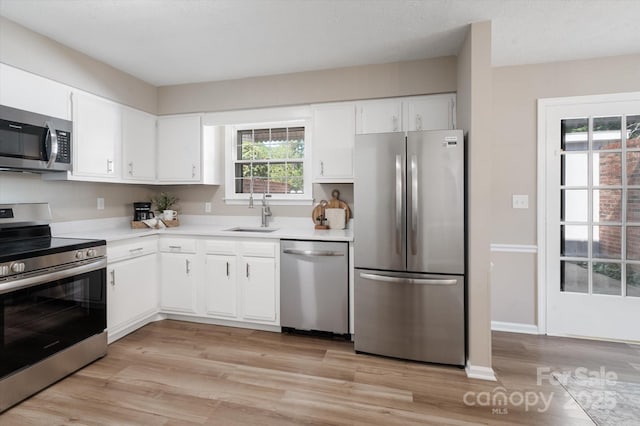 1409 Kensington Rd Unit B-8, Hendersonville, NC 28791 - kitchen with stainless steel appliances, light countertops, light wood finished floors, and white cabinetry