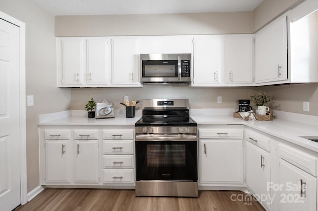 1409 Kensington Rd Unit B-8, Hendersonville, NC 28791 - kitchen featuring appliances with stainless steel finishes, light countertops, white cabinetry, and light wood-type flooring