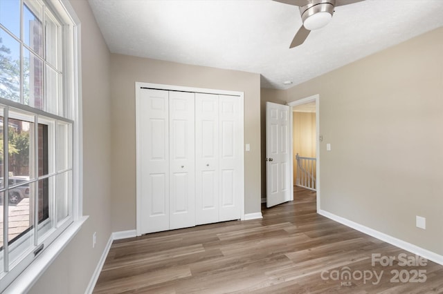 1409 Kensington Rd Unit B-8, Hendersonville, NC 28791 - unfurnished bedroom featuring light wood-style floors, a closet, and a ceiling fan