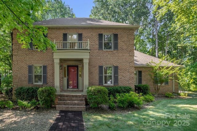 106 Birmingham Pl, Salisbury, NC 28146 - georgian-style home with a balcony, brick siding, roof with shingles, and a front yard