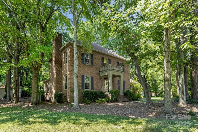 106 Birmingham Pl, Salisbury, NC 28146 - colonial house with a balcony, a chimney, brick siding, and a front lawn