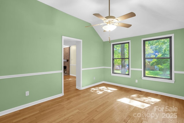 106 Birmingham Pl, Salisbury, NC 28146 - spare room featuring vaulted ceiling, wood finished floors, a ceiling fan, and a brick fireplace