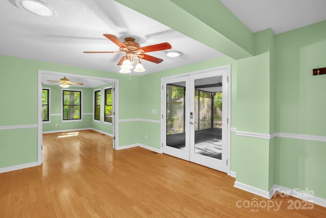 106 Birmingham Pl, Salisbury, NC 28146 - empty room with plenty of natural light, ceiling fan, wood finished floors, french doors, and a textured ceiling