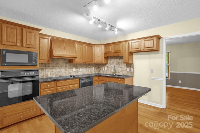 106 Birmingham Pl, Salisbury, NC 28146 - kitchen with black appliances, light wood-style flooring, a textured ceiling, decorative backsplash, and custom exhaust hood