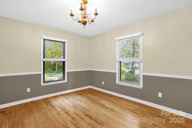 106 Birmingham Pl, Salisbury, NC 28146 - spare room featuring healthy amount of natural light, a chandelier, wood finished floors, and a textured ceiling